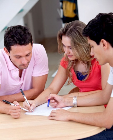 different nationalities come together, three people sitting by a table