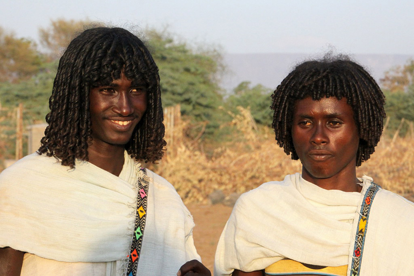 Kaksi etiopialaista miestä perinteisissä valkoisissa asuissa oleva pariskunta.